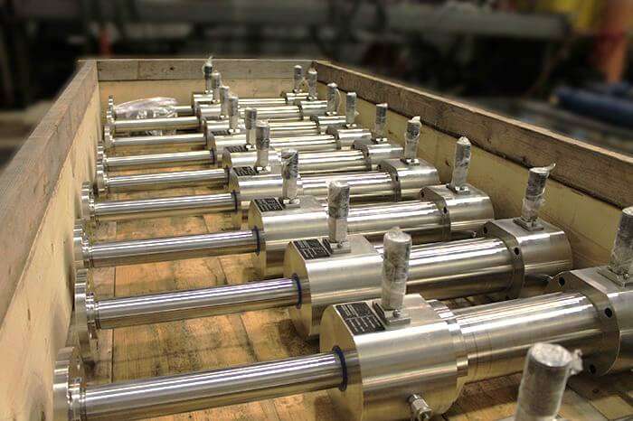 Custom subsea stainless steel, double rod hydraulic cylinders being prepared for shipment in a crate