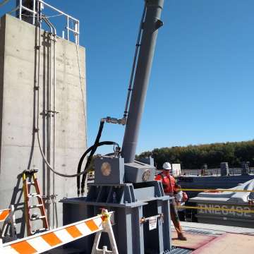 Large, long stroke tainter valve hoisting cylinder with magnetostrictive transducer and custom gimbal mount